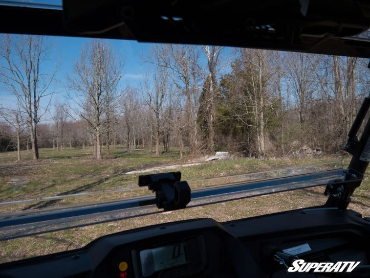 View through the SuperATV flip windshield from inside the Yamaha Wolverine X4 cab looking out at trees