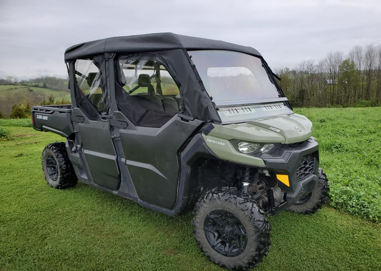 Front three-quarter view of a green Can-Am Defender Max with the 3 Star soft half doors and roof installed