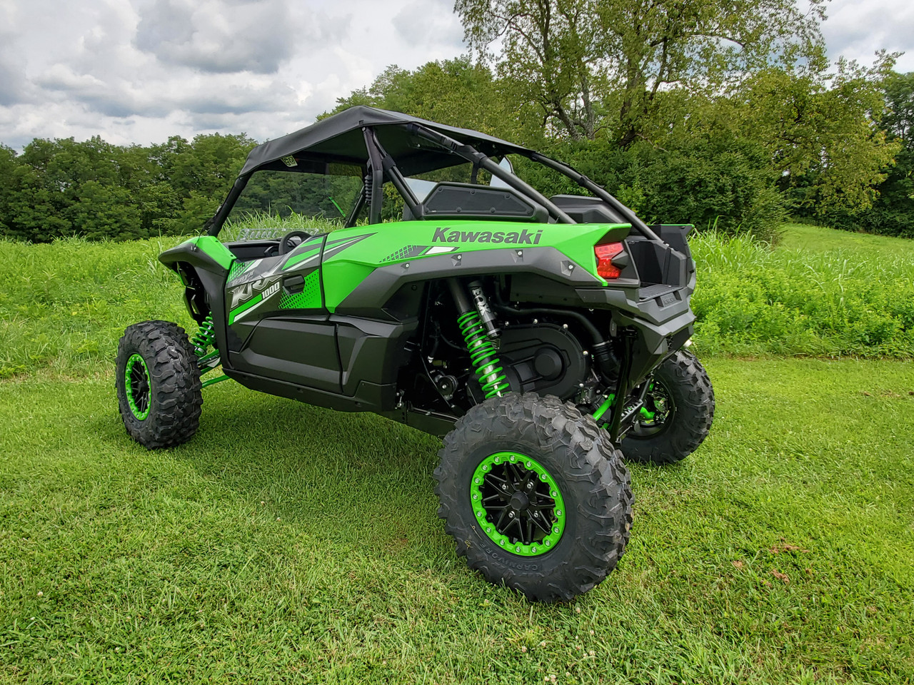Green Kawasaki KRX under a cloudy sky with the 3 Star soft top fitted, rear three-quarter view