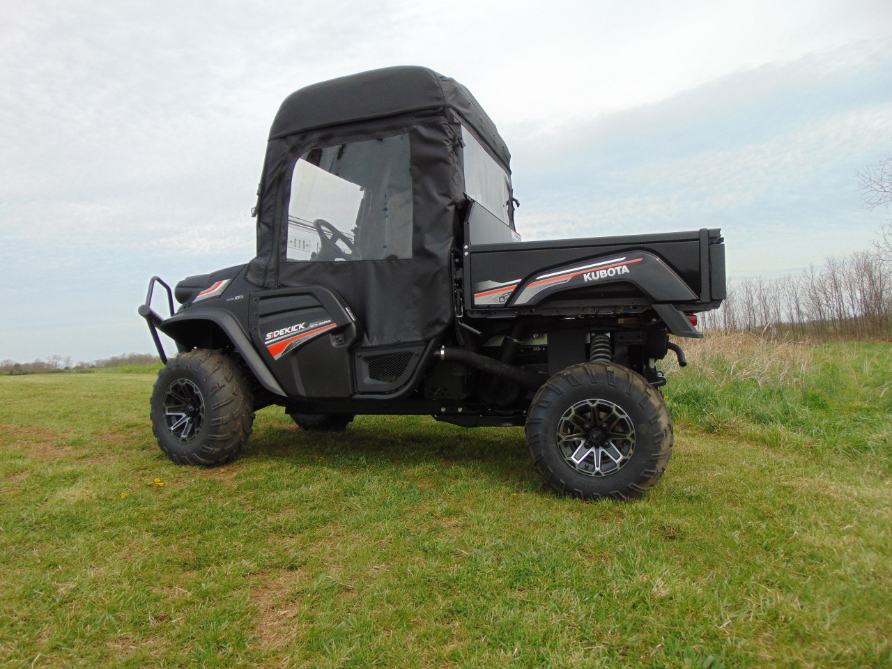 Side view of the black Kubota RTV XG850 with the 3 Star vinyl windshield and soft doors installed