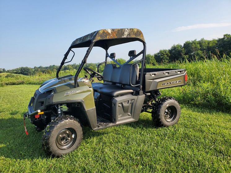 3 Star camo soft top on a green Polaris Ranger 570-3, driver side front angle in a grassy field