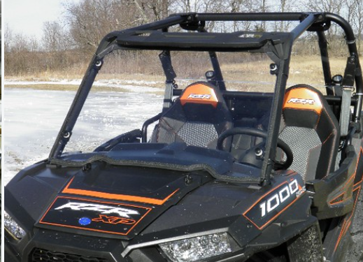 Front view of the 3 Star one-piece windshield on a black and orange Polaris RZR XP1000 with snow on the ground