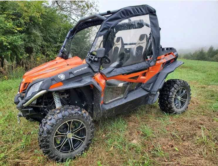 3 Star soft doors installed on an orange CFMoto ZForce, front three-quarter view in a foggy field