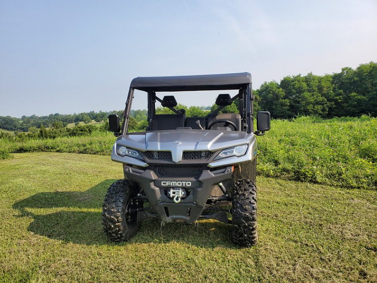 Front view of a grey CF Moto UForce 1000 with the 3 Star soft top installed, parked on mowed grass