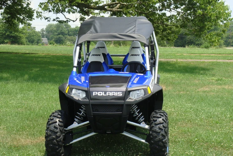 Front view of a blue four-seat Polaris RZR with silver cage wearing the 3 Star black soft top