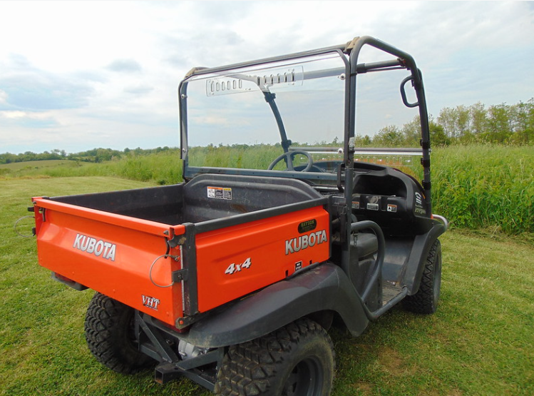 Rear three-quarter view of an orange Kubota RTV X900/X1120D with the 3 Star Lexan rear window installed