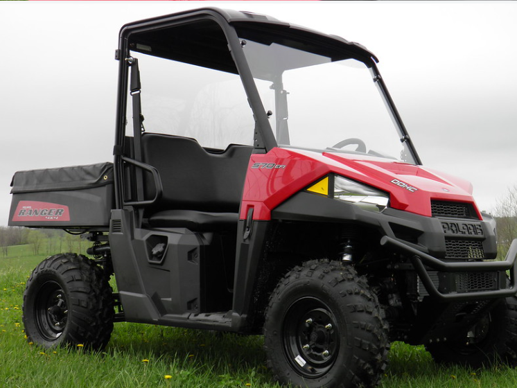 Front three-quarter view of a red side-by-side with the 3 Star two-piece windshield and roof installed in a field