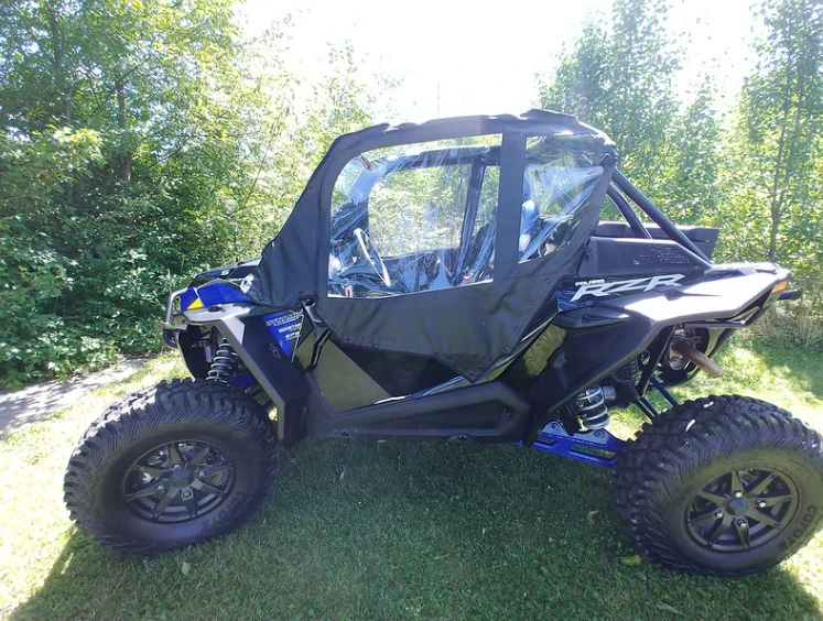 Side view of a blue Polaris RZR XP Turbo S with the 3 Star soft upper doors with clear windows near trees