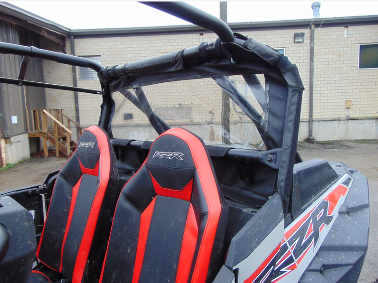 3 Star soft back panel with clear window behind the rear seats of a red RZR XP 4 Turbo S, side view in a lot