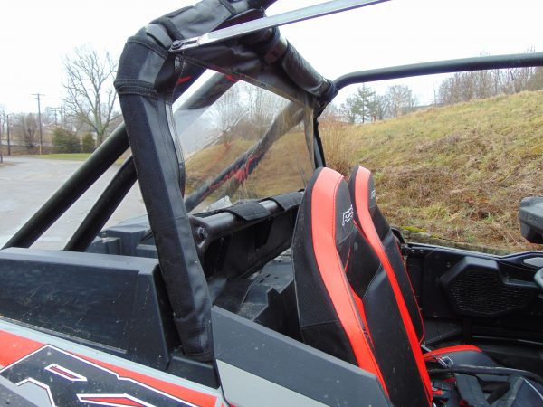 Passenger side view of the 3 Star soft back panel clear window and roll cage straps on a red RZR XP 4 Turbo S