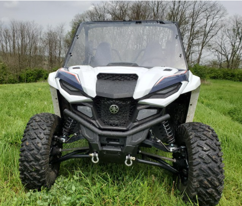 Straight front view of a white Wolverine RMAX2/4 with the 3 Star one-piece windshield installed, winch bumper in front