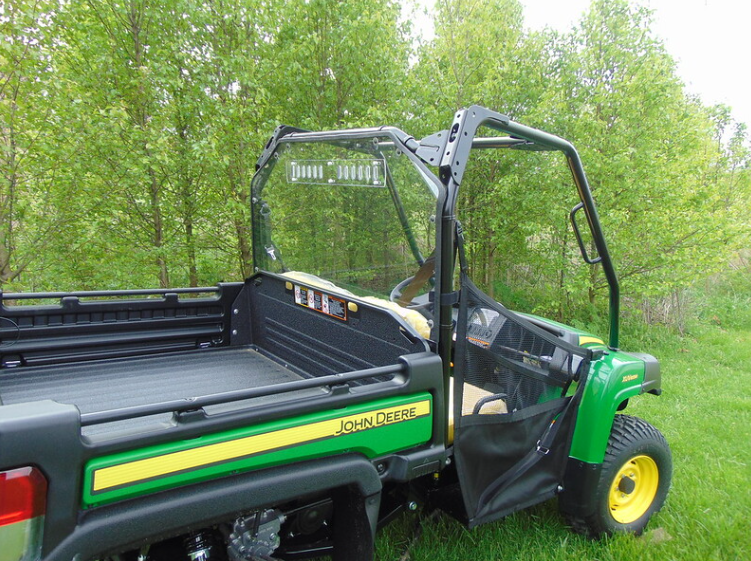 Rear three-quarter view of the green and yellow John Deere Gator XUV with the 3 Star Lexan back panel behind the cab