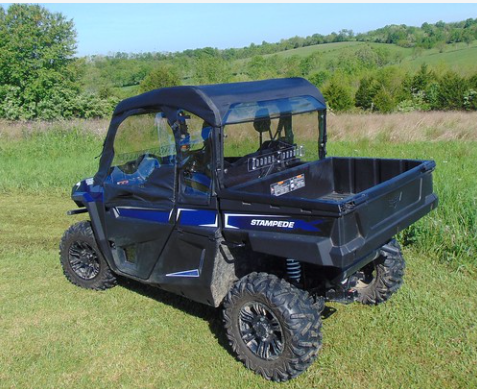 Rear three-quarter view of the blue Arctic Cat Stampede with a soft top and the 3 Star back panel in a field