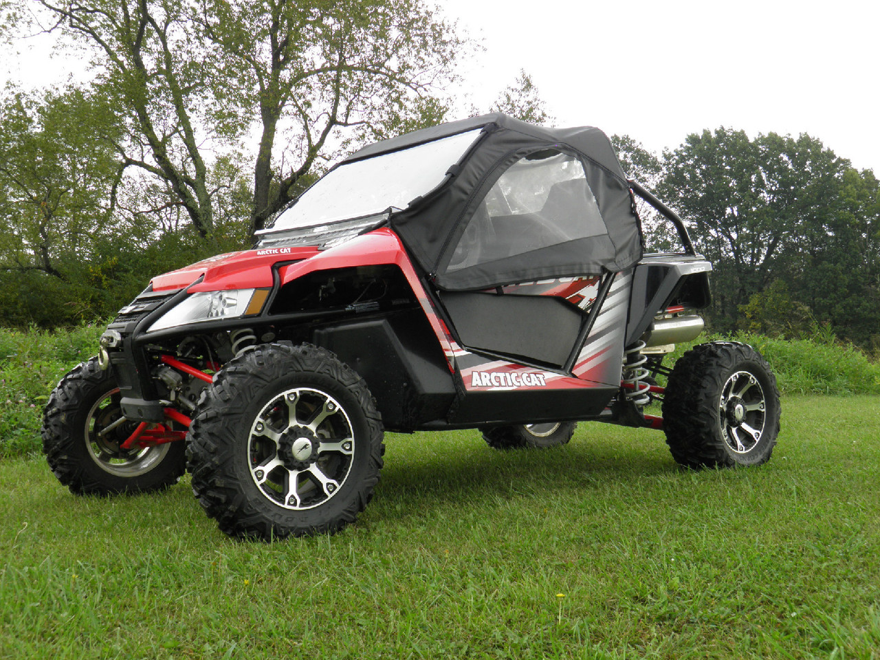 Side profile of the 3 Star cab enclosure on the red Arctic Cat Wildcat showing the full door with clear window