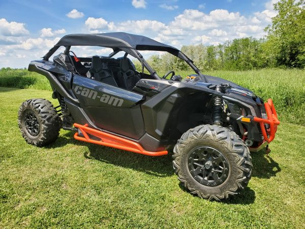 Driver side front three-quarter view of a black Can-Am Maverick X3 with the 3 Star soft top and orange trim