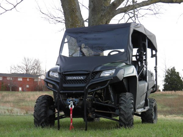 Front three-quarter view of a green Honda Pioneer 700-4 with the 3 Star vinyl windshield and top under a tree