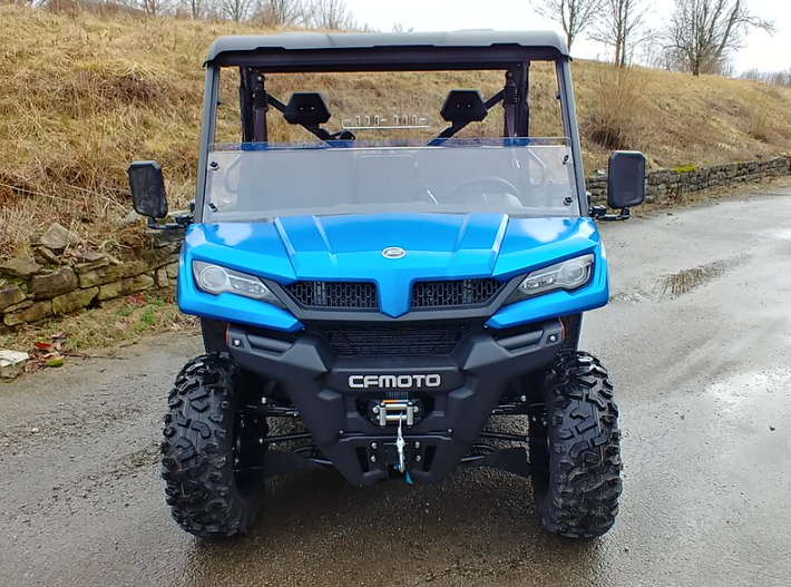 3 Star clear half windshield on a blue CF Moto UForce 1000, front view on a wet road