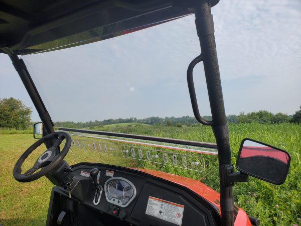 View from the driver seat through the 3 Star 2-piece windshield of a Coleman 400, steering wheel and mirror