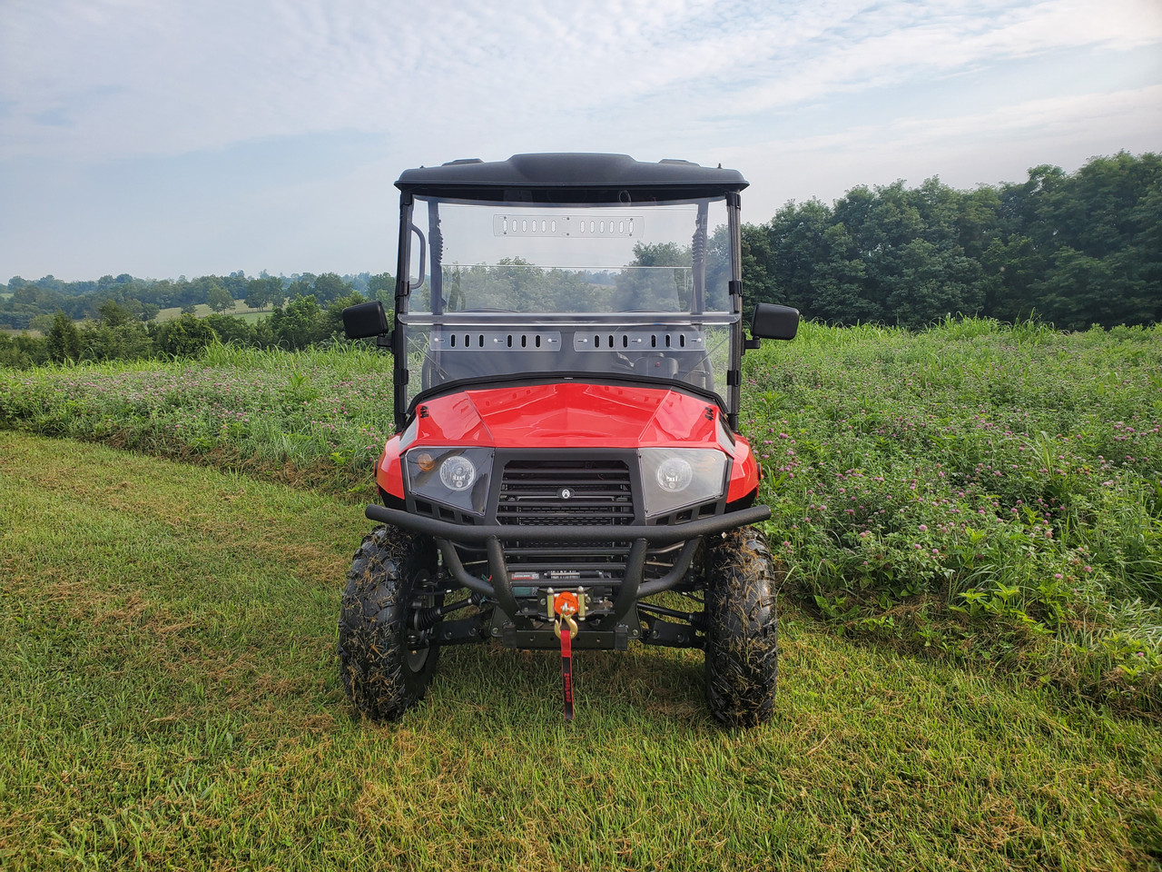 Direct front view of a red Coleman 400 with the 3 Star 2-piece windshield and roof, parked in a field