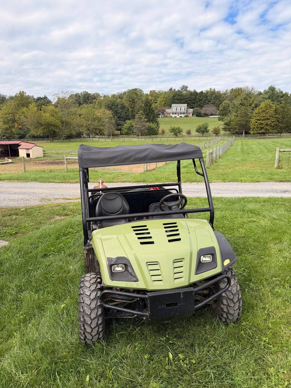 Front view of a Cub Cadet Volunteer UTV with the black Greene Mountain soft top roof cover installed