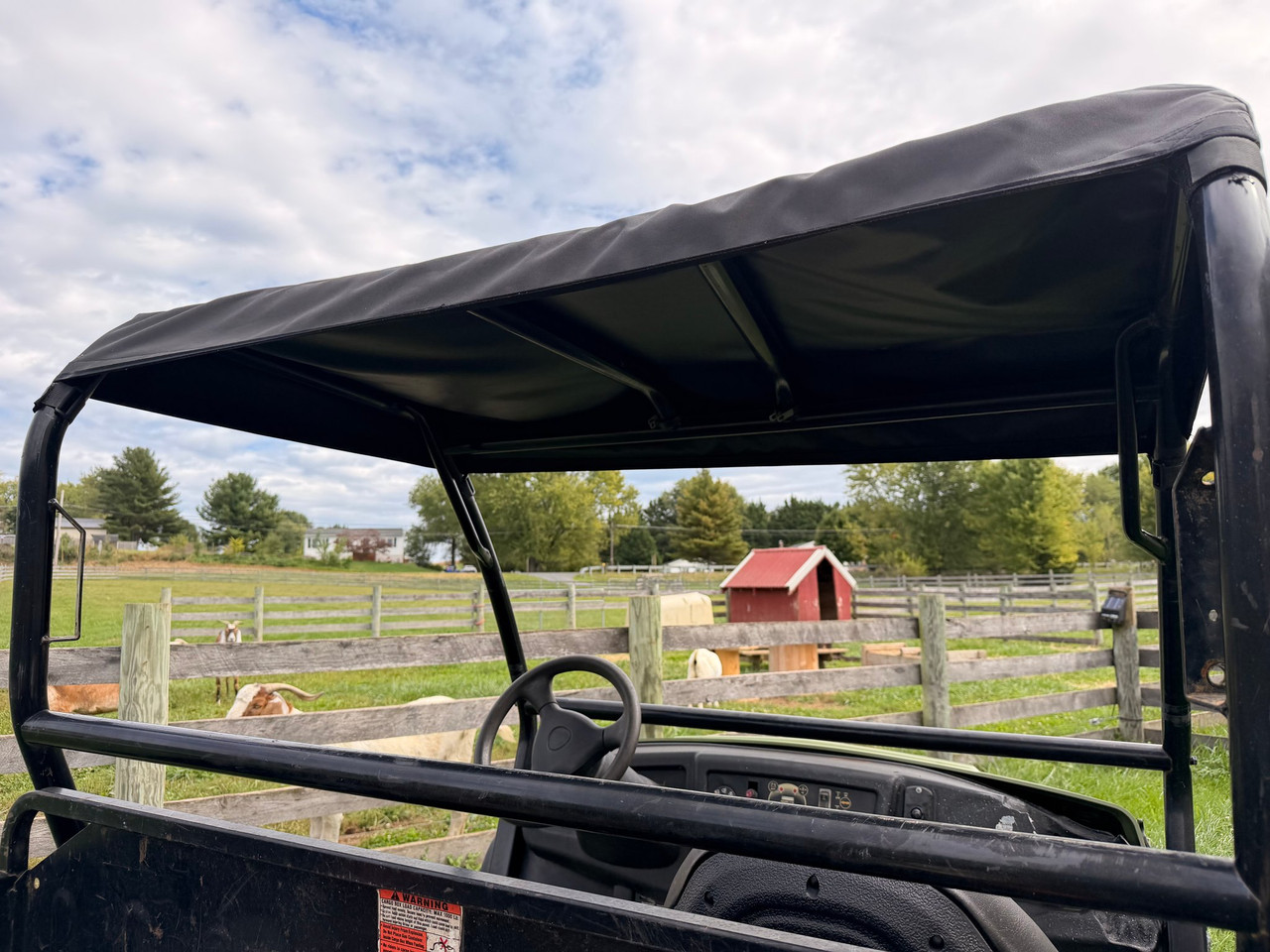 Underside of the black Cub Cadet Volunteer roof cover showing how it fastens to the roll bars