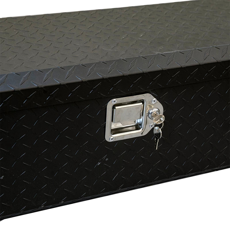 Close-up of the chrome paddle latch and keys on the diamond plate front of the Kolpin UTV aluminum bed box