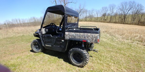 3 Star vinyl top, windshield and rear window on a black Cub Cadet Challenger 500, rear three-quarter view in a field