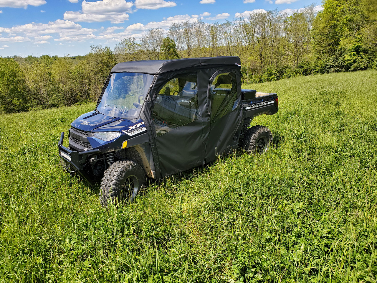 3 Star full cab enclosure with hard windshield on a blue Polaris Ranger 1000 Crew, front three-quarter view