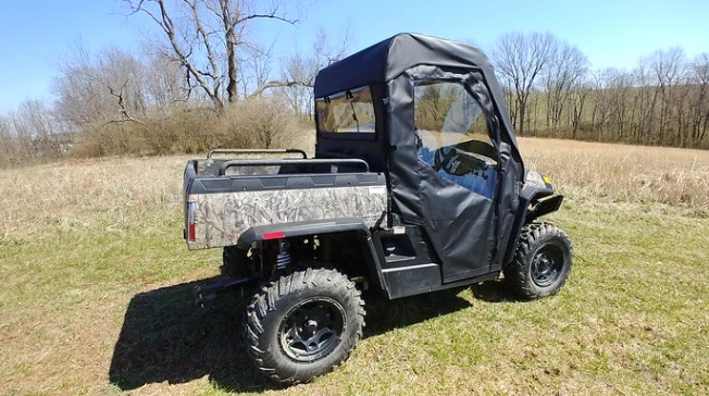 Passenger side view of the 3 Star full cab enclosure doors with clear windows on a camouflage Hisun 700
