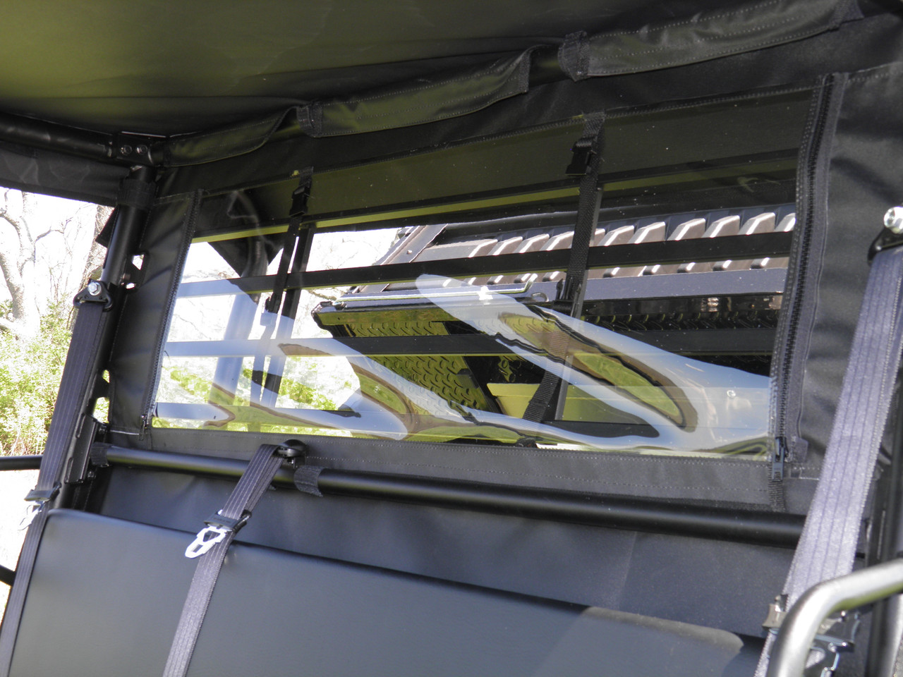3 Star soft back panel with clear window seen from inside the cab of a Kawasaki Mule ProMX, straps and cage behind