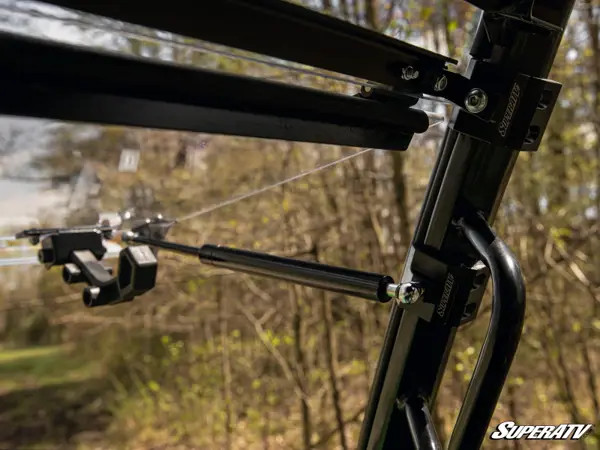 Close-up of the SuperATV flip windshield hinge and gas strut on the Gator XUV835 cage