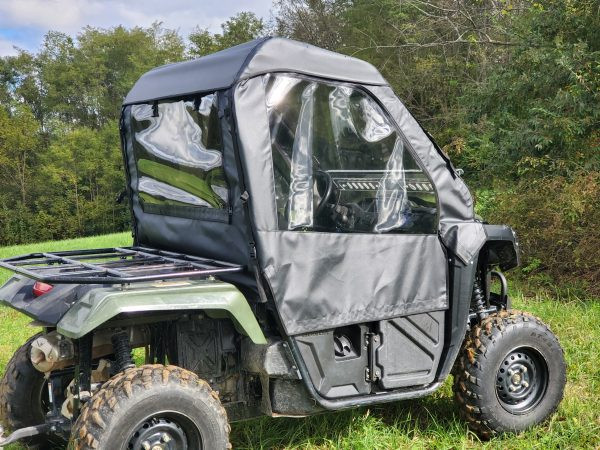 Passenger side view of the 3 Star soft doors and rear window on a green Honda Pioneer 500 parked on grass
