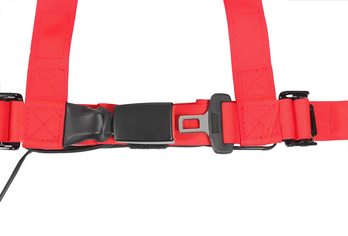 Red Pro Armor harness webbing with the auto-style buckle latched, close-up of the lap belt junction