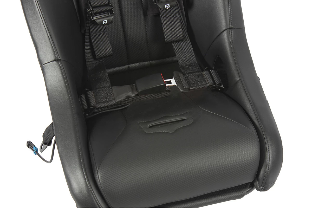 Angled close-up of the Pro Armor harness buckle with red release button on the seat cushion