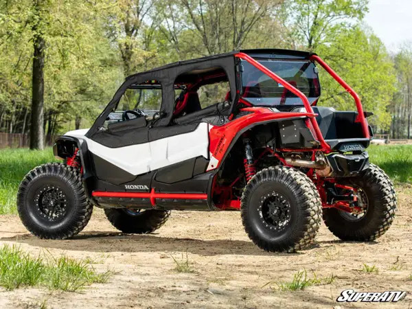 Rear three-quarter view of the Honda Talon 1000X-4 with SuperATV soft upper doors and roof in a wooded clearing
