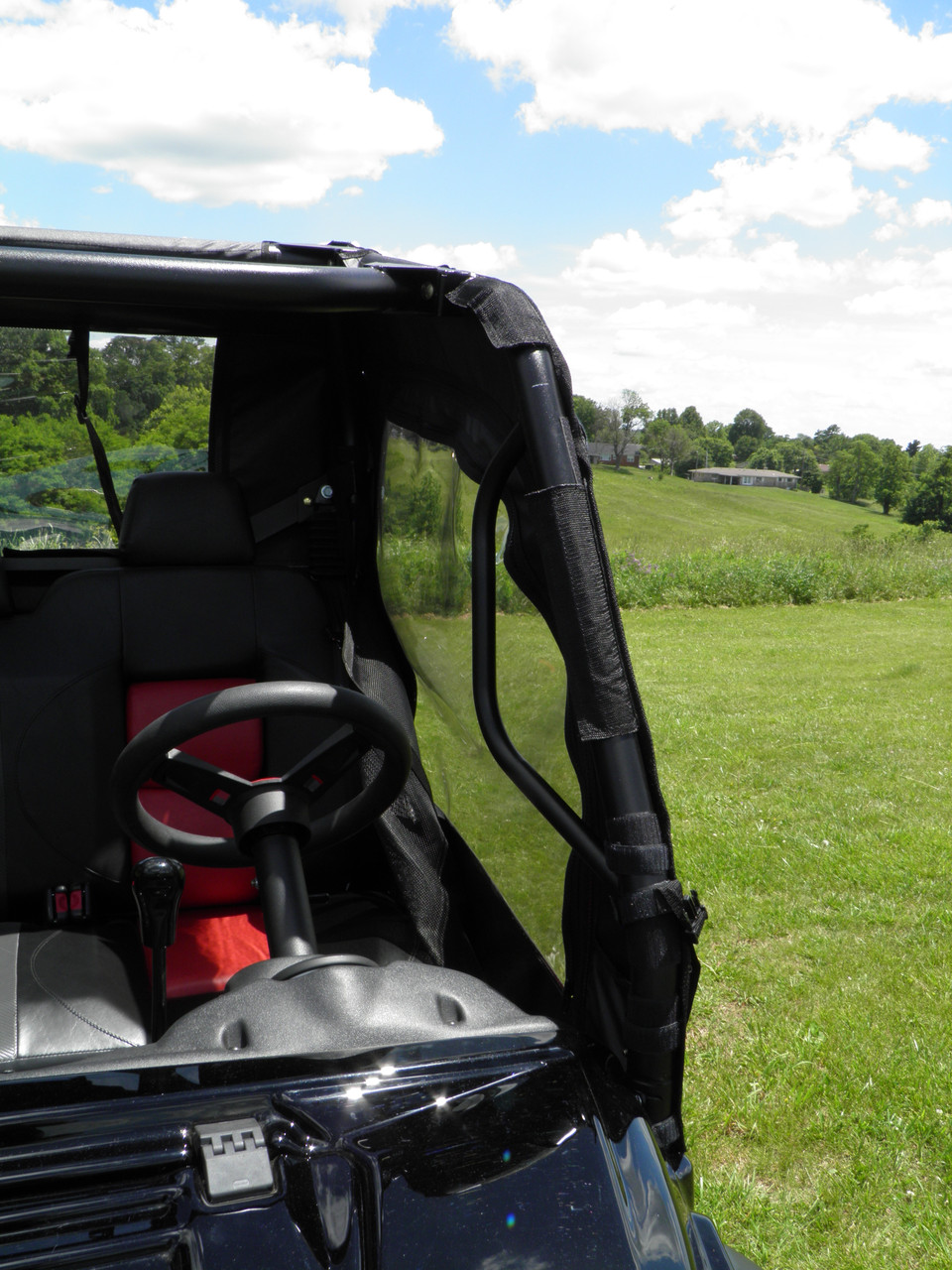 View from inside the Intimidator GC1K cab of the 3 Star soft door frame strap beside the steering wheel