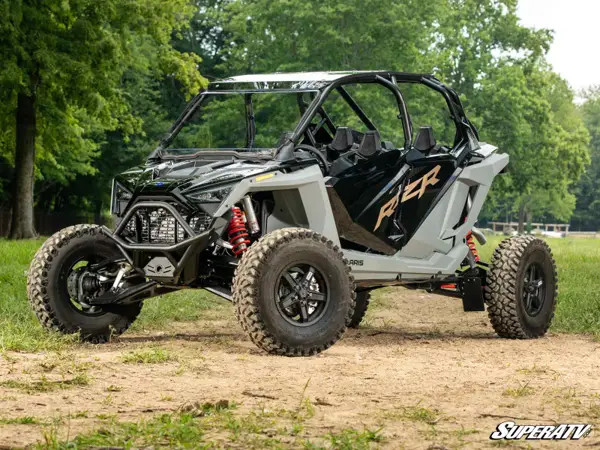 Side profile of a gray four-seat Polaris RZR Pro R with the SuperATV front bumper, parked under trees