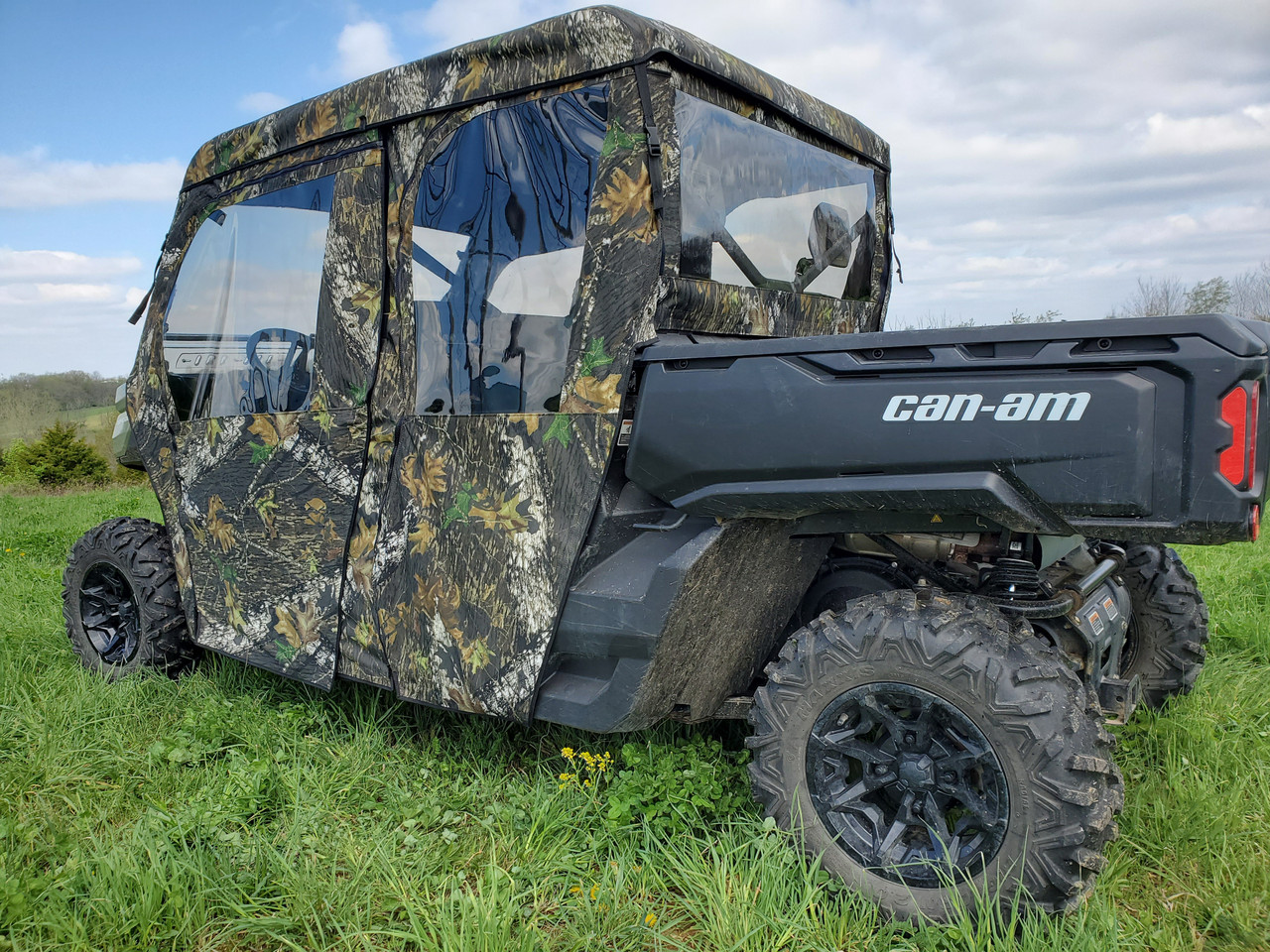3 Star full door and rear window combo in Mossy Oak camo on a Can-Am Defender Max 4, rear three-quarter view in a field