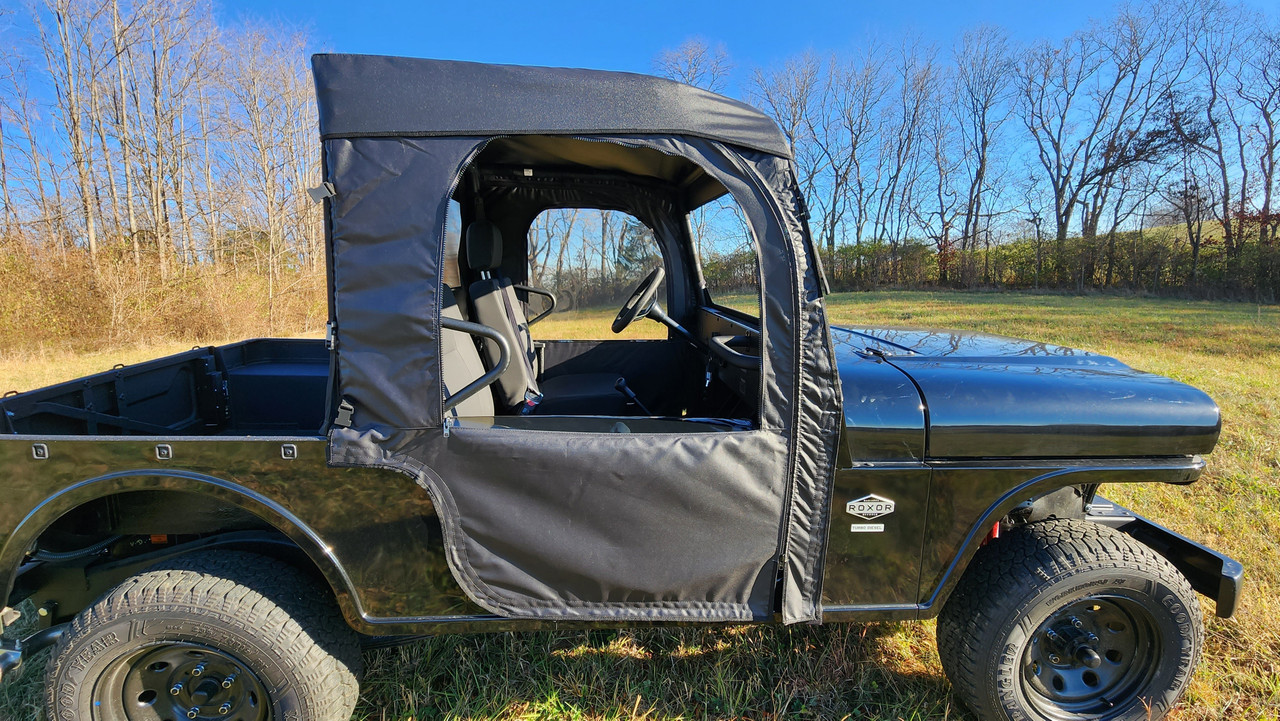 Driver side profile of the 3 Star full doors and soft top on a black Mahindra Roxor in a winter field