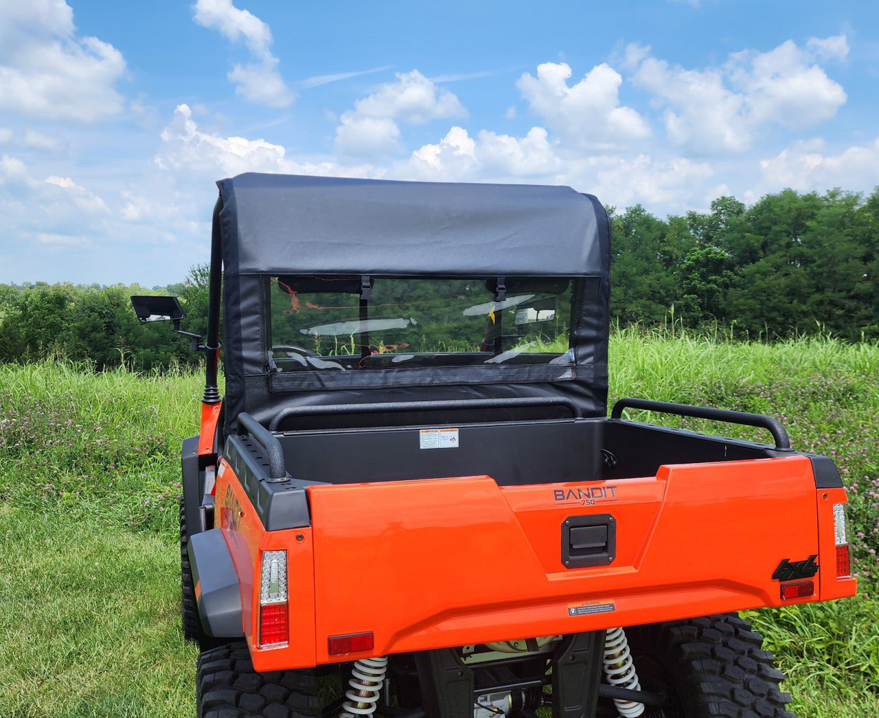 Rear view of an orange Bad Boy Bandit 750 with the 3 Star rear window panel installed behind the cab