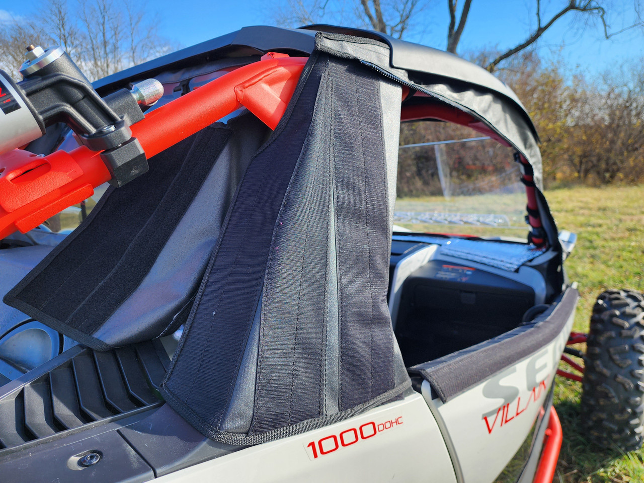 Close-up of the 3 Star upper soft door on a Segway Villain beside the red cage, black fabric with the rear window behind