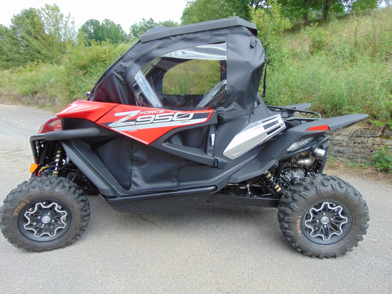3 Star full cab enclosure with upper doors, rear panel and top on a red CFMoto ZForce 950, driver side profile on pavement
