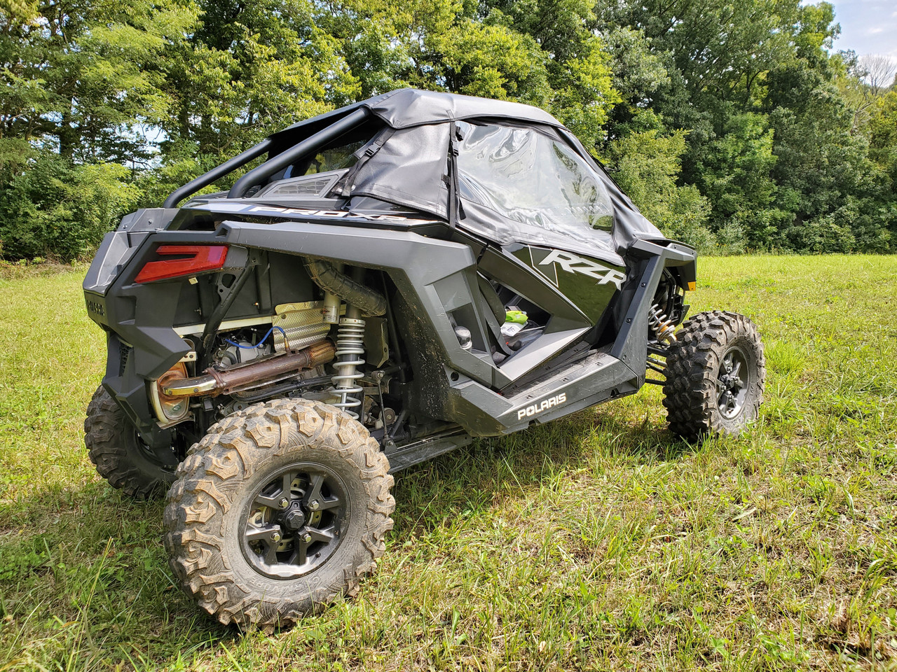 3 Star full cab enclosure for hard windshield on a black Polaris RZR PRO XP, rear three-quarter view in a field