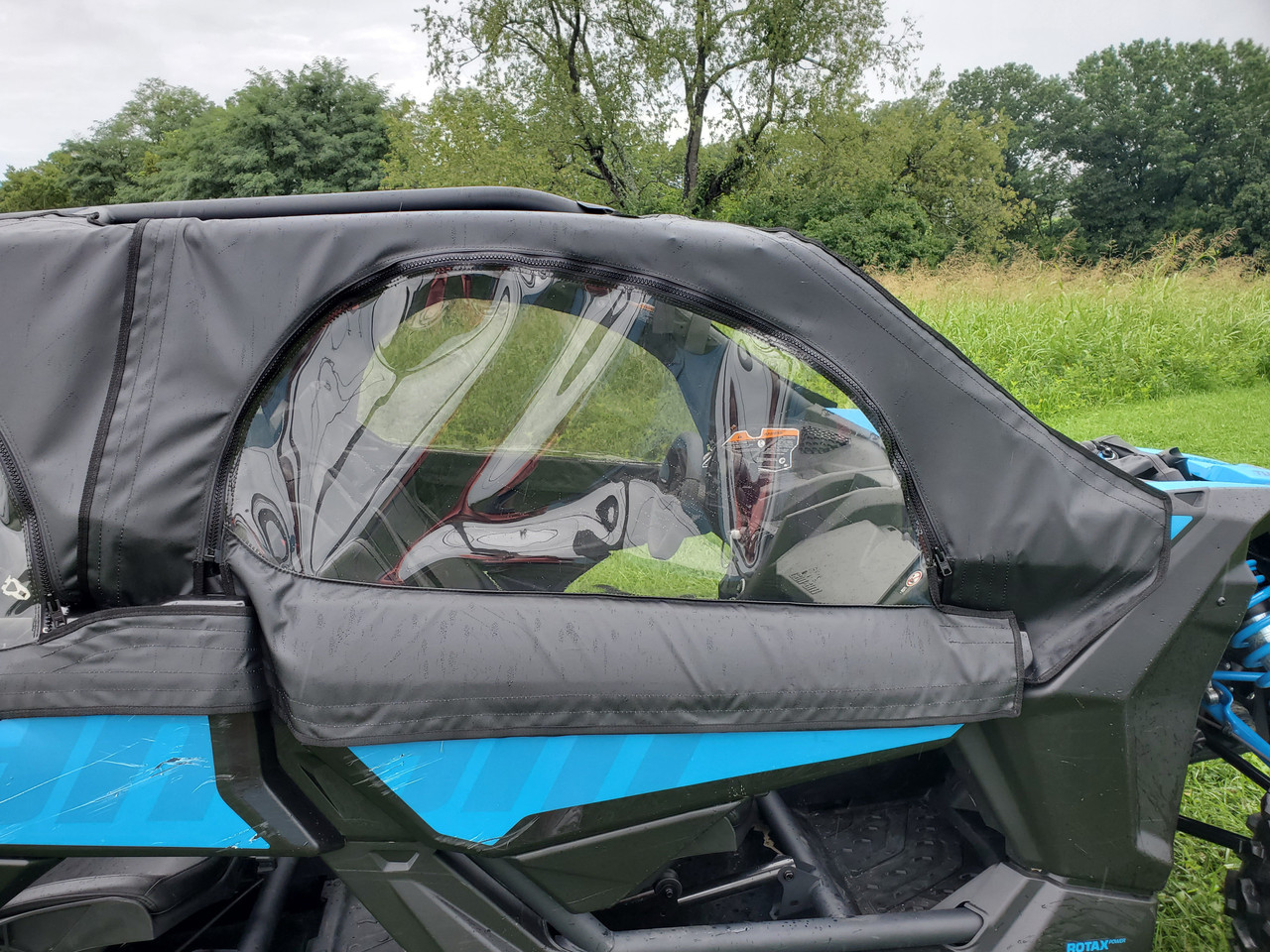 Close-up of a 3 Star soft upper door with clear window on the rear seat of a blue Can-Am Maverick X3 Max
