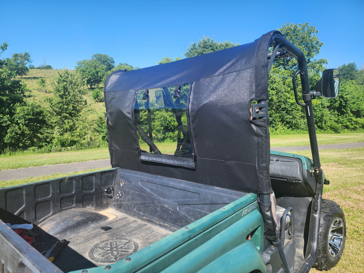 3 Star rear window panel installed behind the seats of a green Yamaha Rhino, rear corner view over the bed