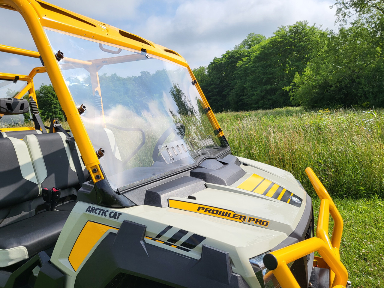 Close-up of the 3 Star one-piece windshield from the passenger side front corner showing the yellow cage and hood