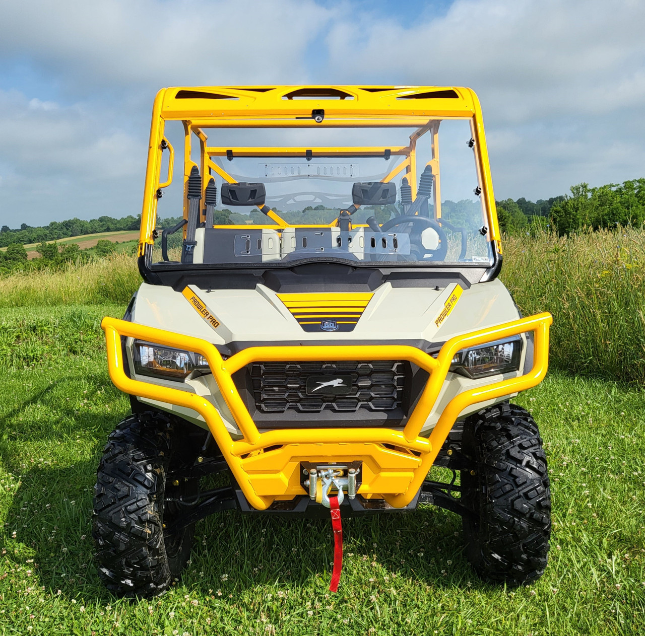 Front view of a tan and yellow Arctic Cat Prowler PRO Crew with the 3 Star one-piece windshield installed