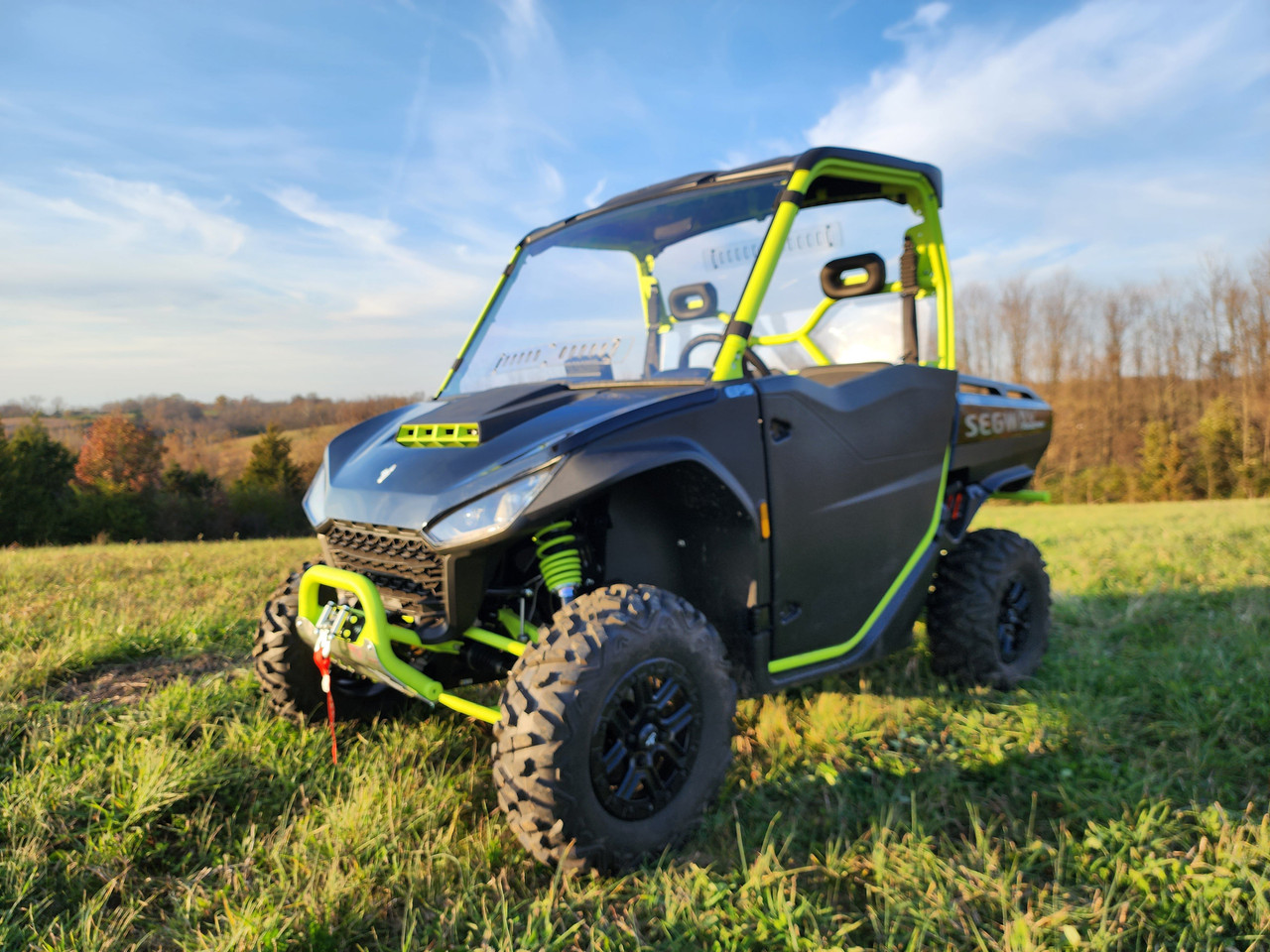 Black and green Segway UT10 with the 3 Star scratch-resistant windshield, front three-quarter view in a field