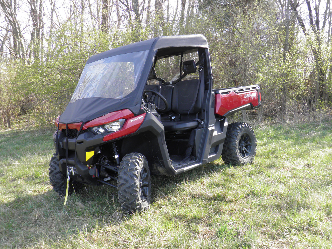 3 Star vinyl windshield and top combo on a red Can-Am Defender, front three-quarter view in a field by trees