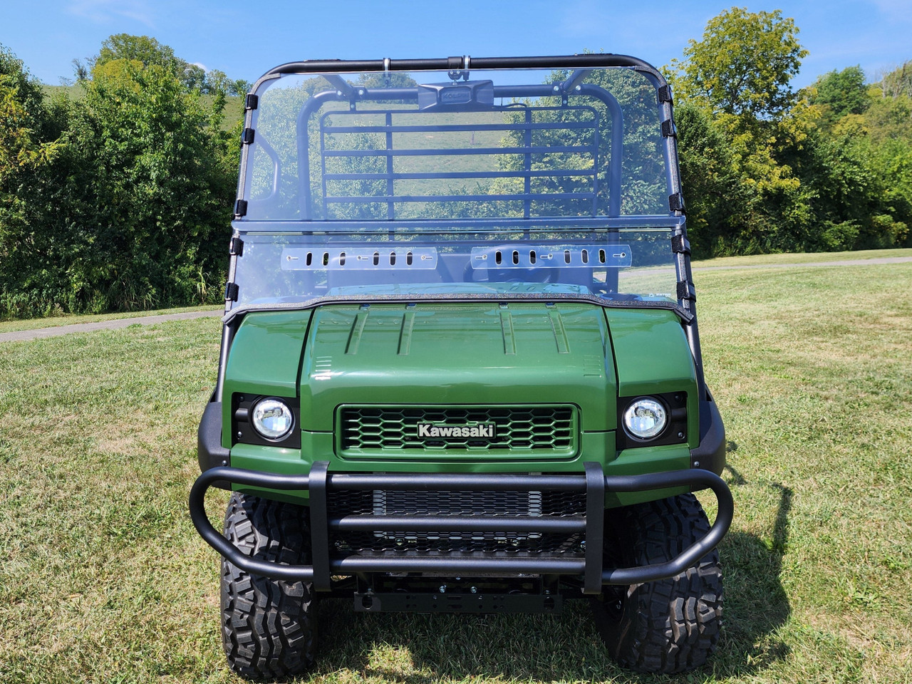 Green Kawasaki Mule 4010 parked on grass with the 3 Star 2-piece windshield fitted, wide straight front view